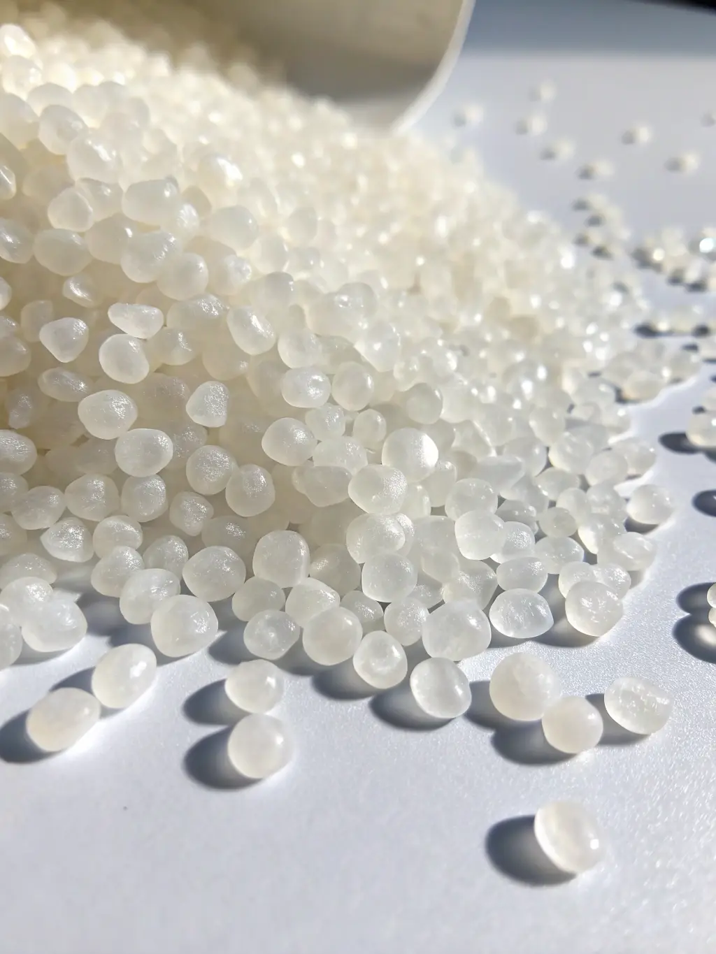 A microscopic view of polyethylene granules, clearly showing their uniform size and shape. The image is taken in a quality control lab with precision measurement tools visible in the background.